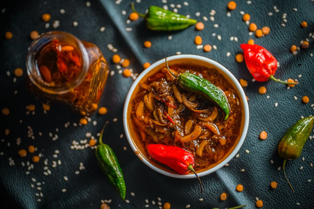 Bowl of spicy naga chilli dish with fresh red and green chillies on a dark surface
