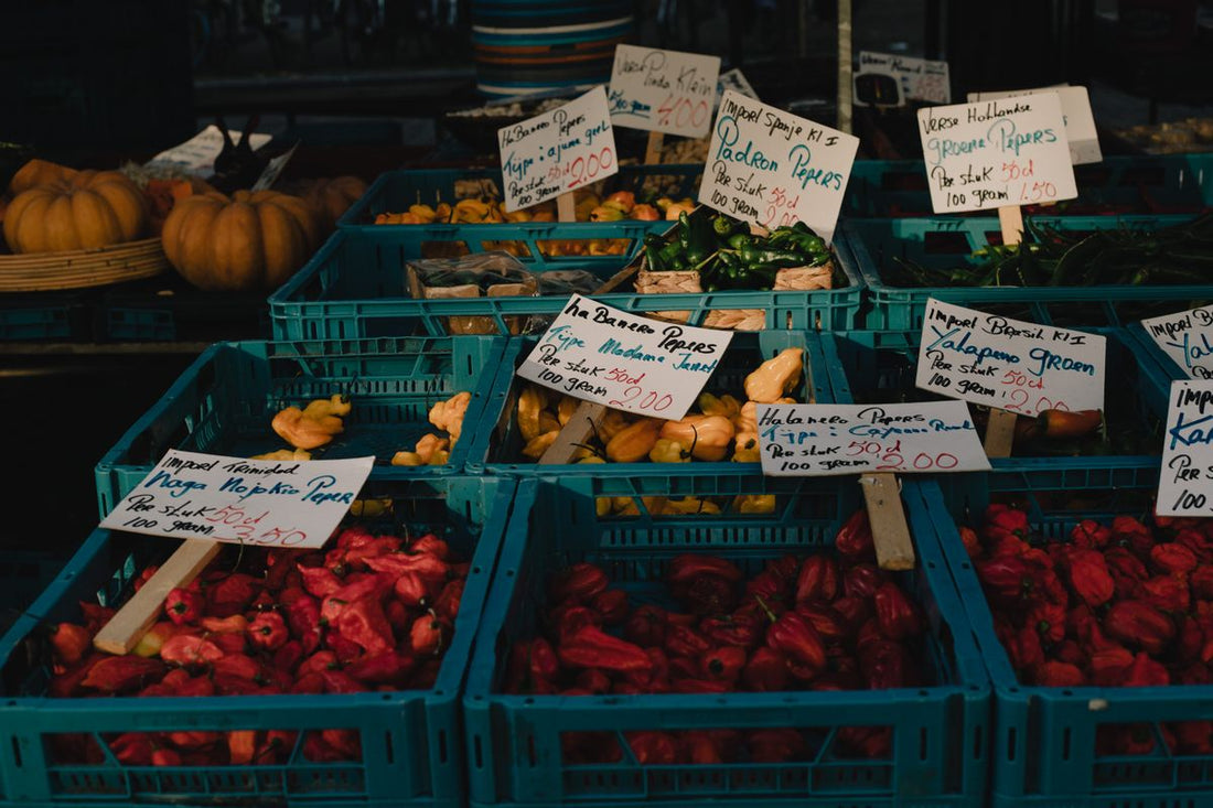 Crates of fresh chillies and peppers at a produce market stall