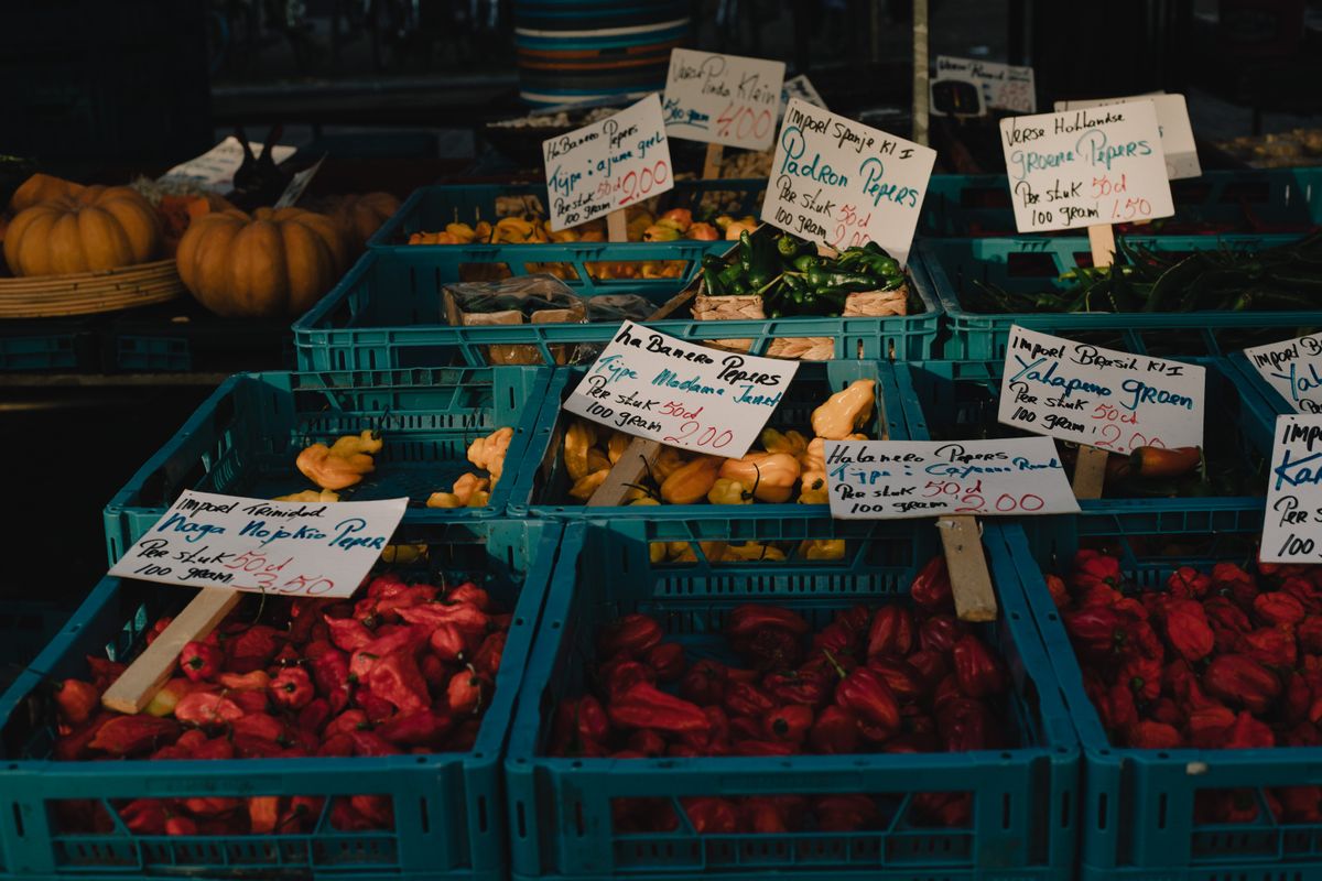 Crates of fresh chillies and peppers at a produce market stall