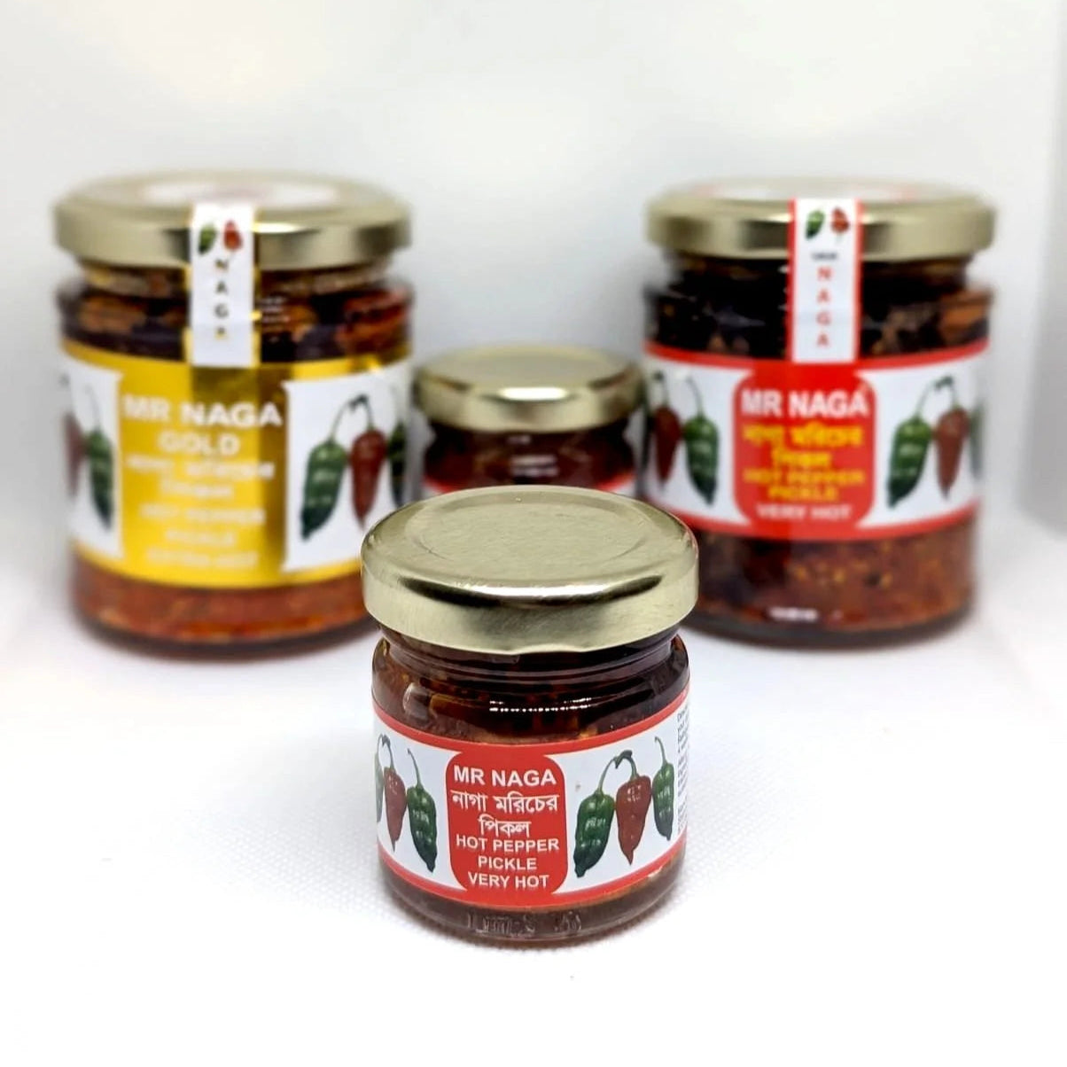 Three jars of Mr Naga Gold hot pepper pickle on a white background