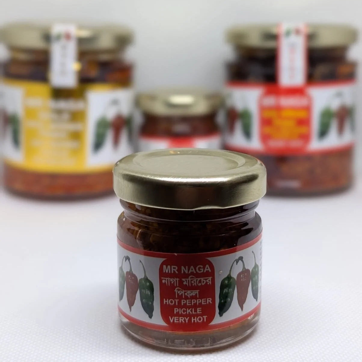 Jars of Mr Naga hot pepper pickle on a white background
